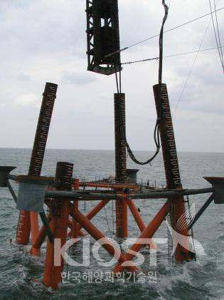 하부 재킷 구조물을 해저에 고정시키기 위한 파일을 삽입하고 항타하는 공정 의 사진