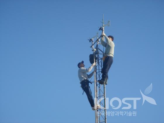 이어도 기지에서 연구원들이 기상타워의 관측장비를 설치/점검하는 모습 의 사진
